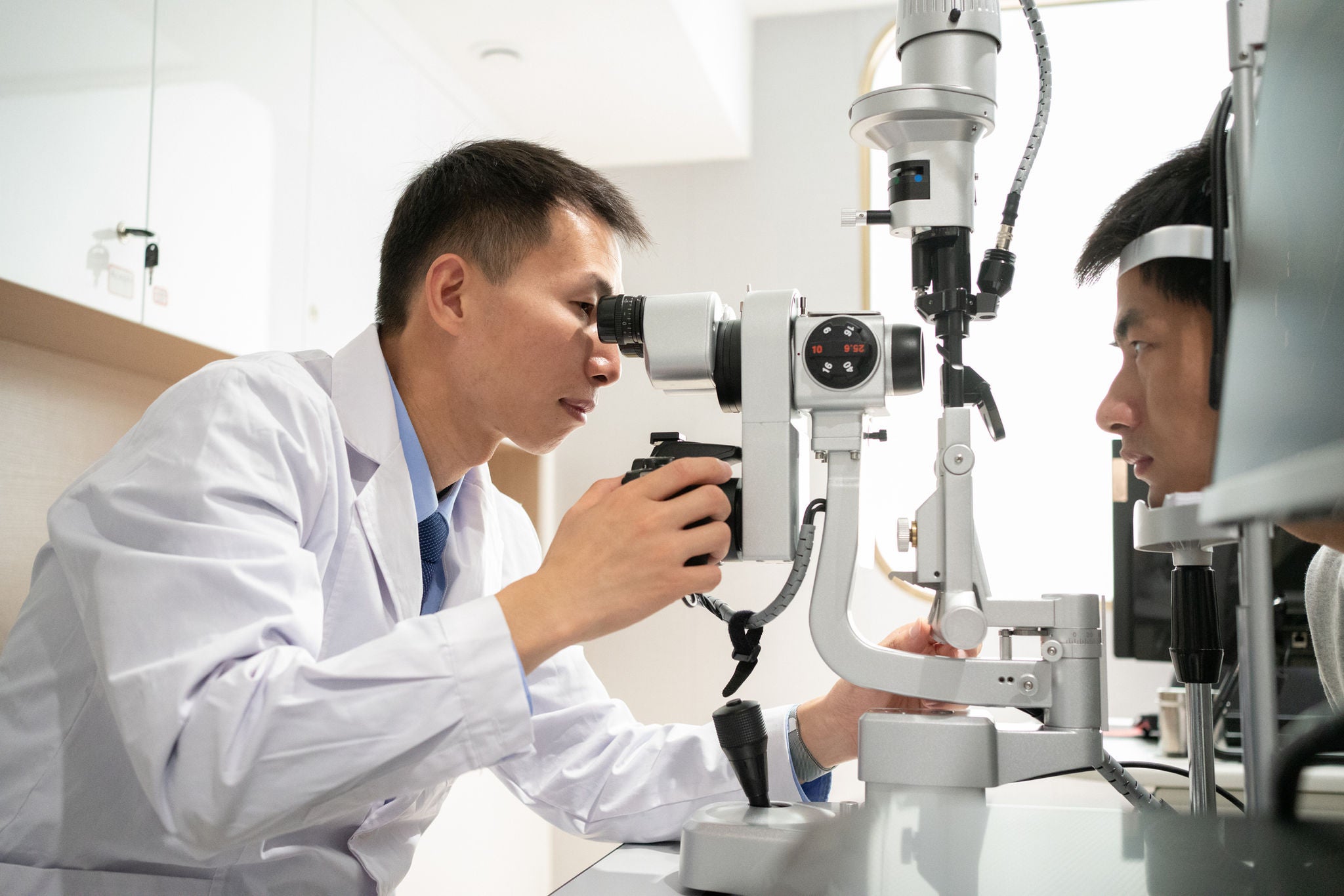 The ophthalmologist is examining the eyes of the patient