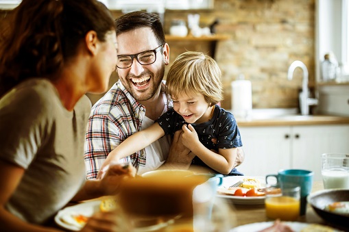 Cheerful family having fun during their meal at dining table.
