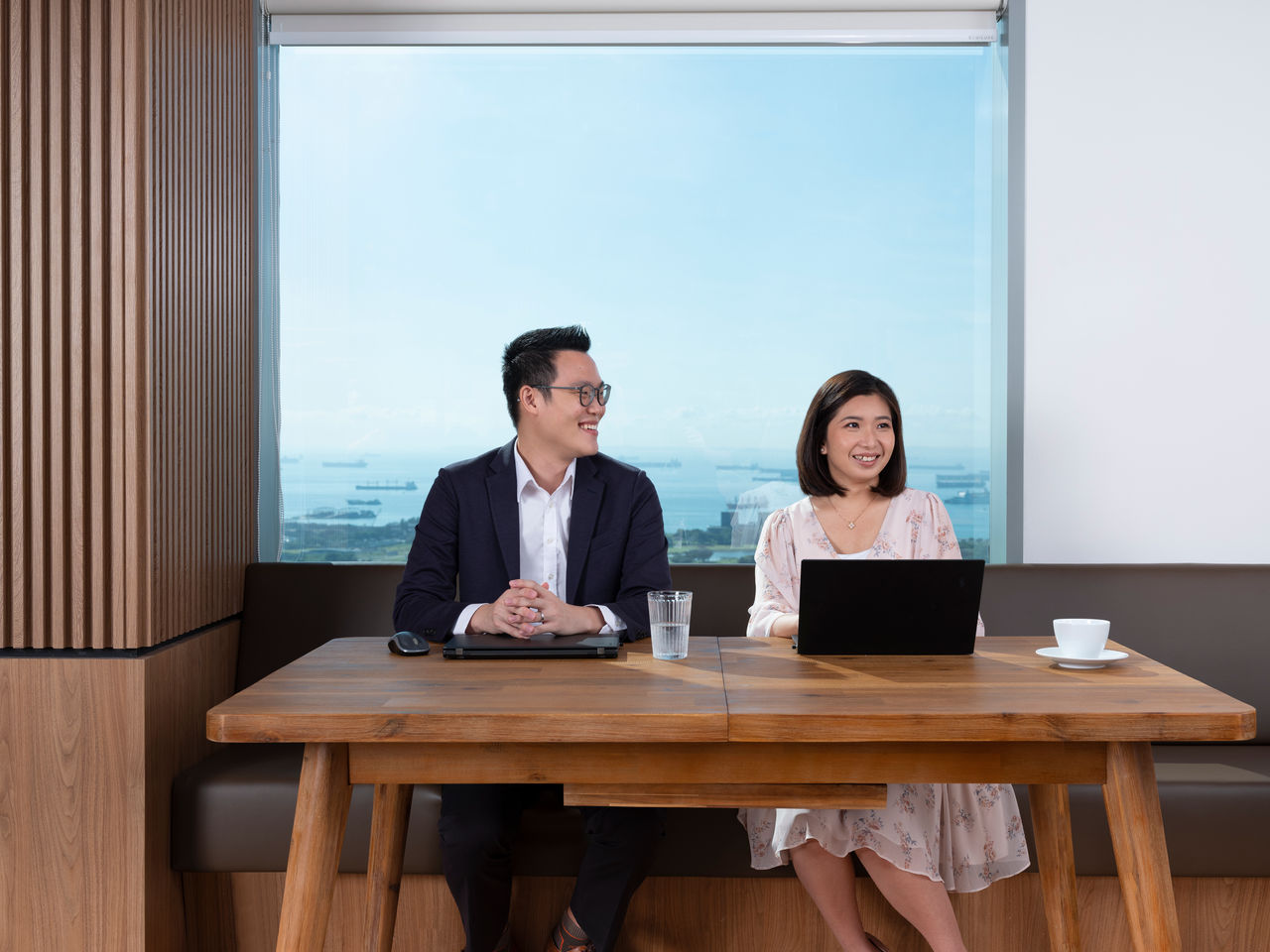 Two Santen employee seated side-by-side while working on their laptops at a collaboration area in the office. 