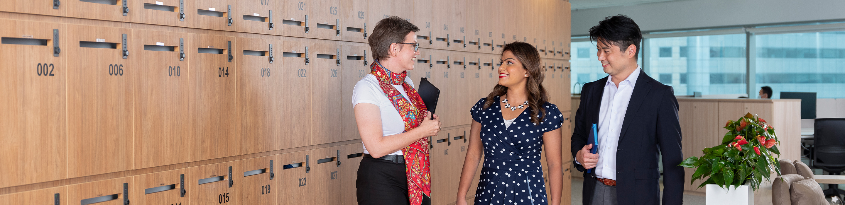 Santen colleagues of diverse ethnicities having a conversation while walking along the office corridor.