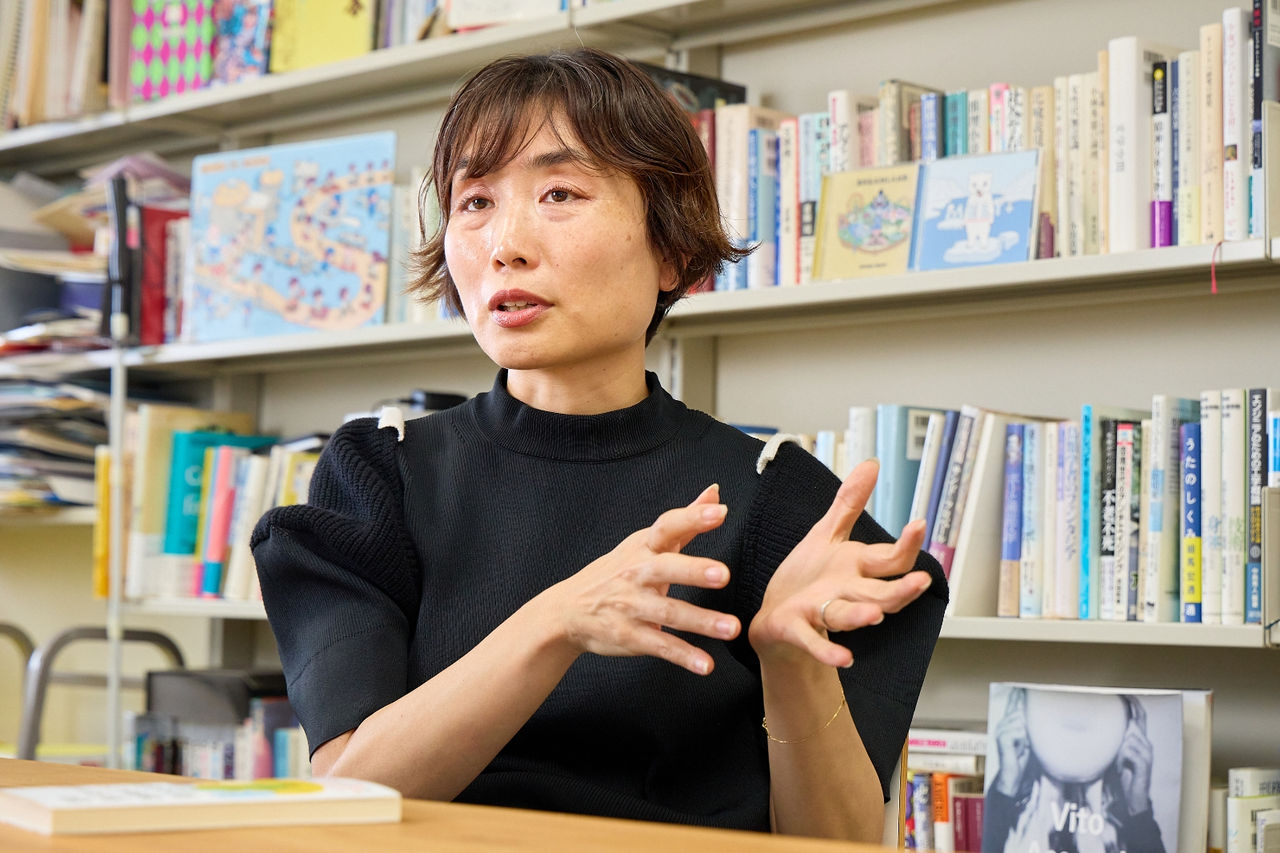 A photograph of Professor Ito answering questions in the research lab