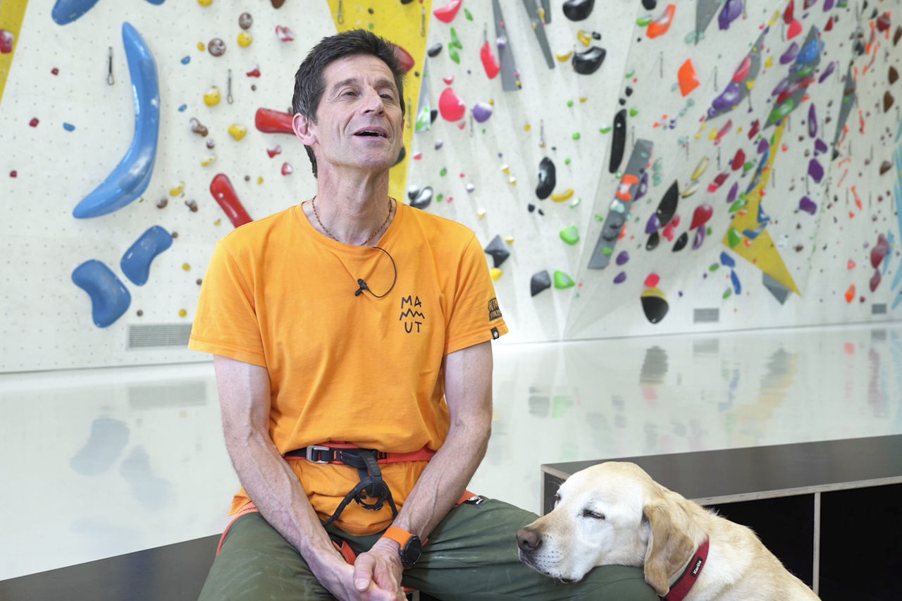 A photo of Roland answering interview questions with his guide dog
