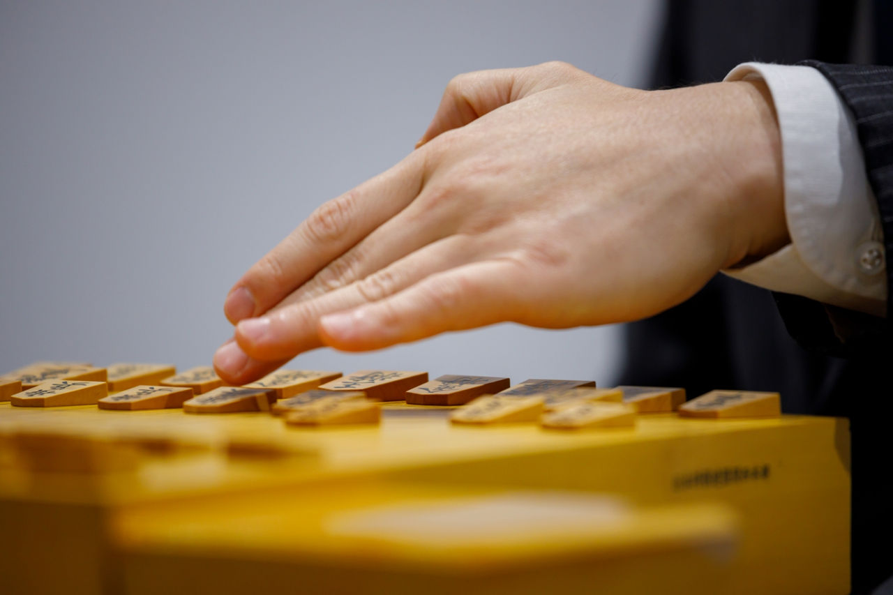 A close-up photo of Takayuki’s hands playing shogi 