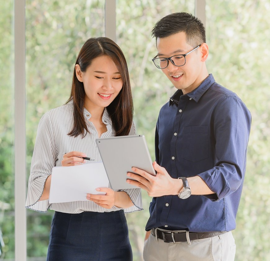 Entrepreneur Asian businessman and woman discussing new business project in tablet in modern meeting room