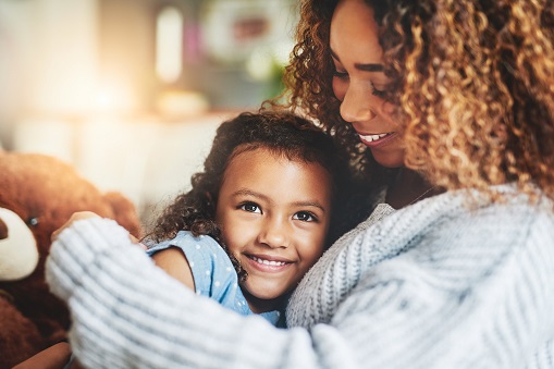 Shot of an adorable little girl and her mother in a warm embrace at home